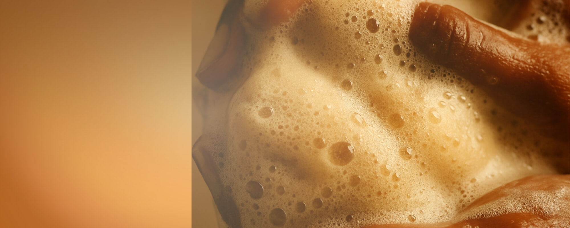 Close-up of a hand holding a bar of soap with sudsy foam.
