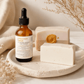 Bottle of face serum with two soap bars on a stone surface